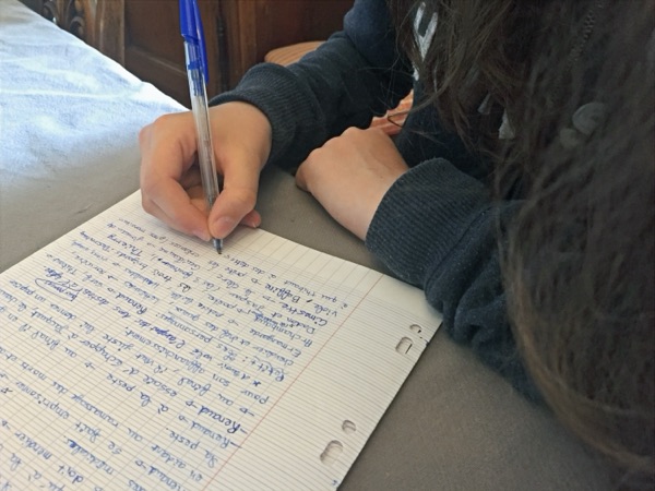 Main écrivant dans un cahier
